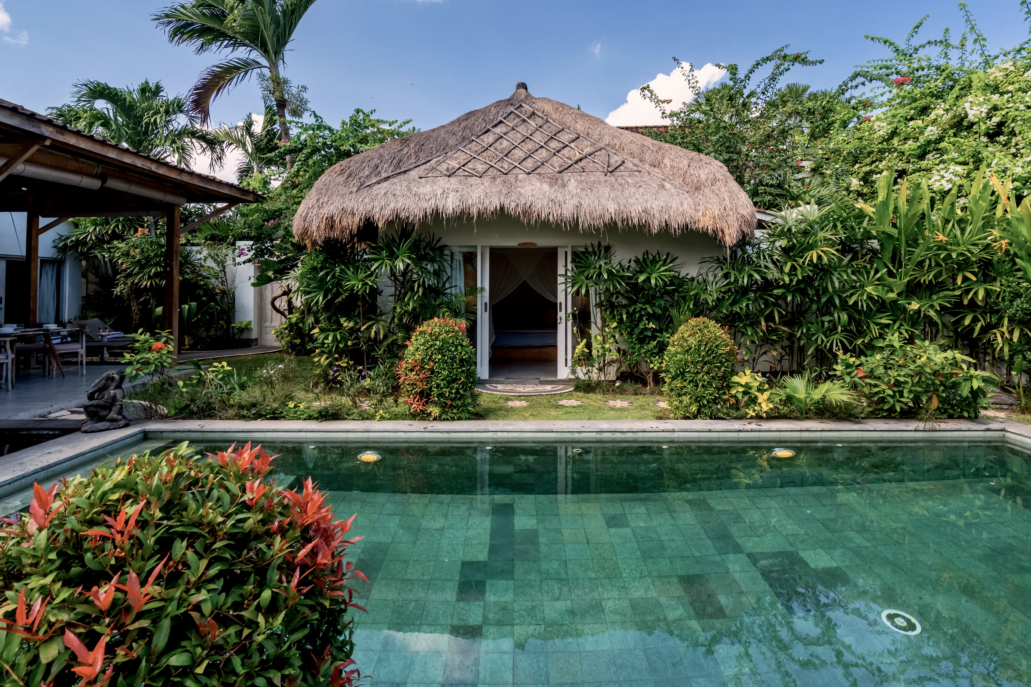 The thatched bale at the head of the pool, seen across the water