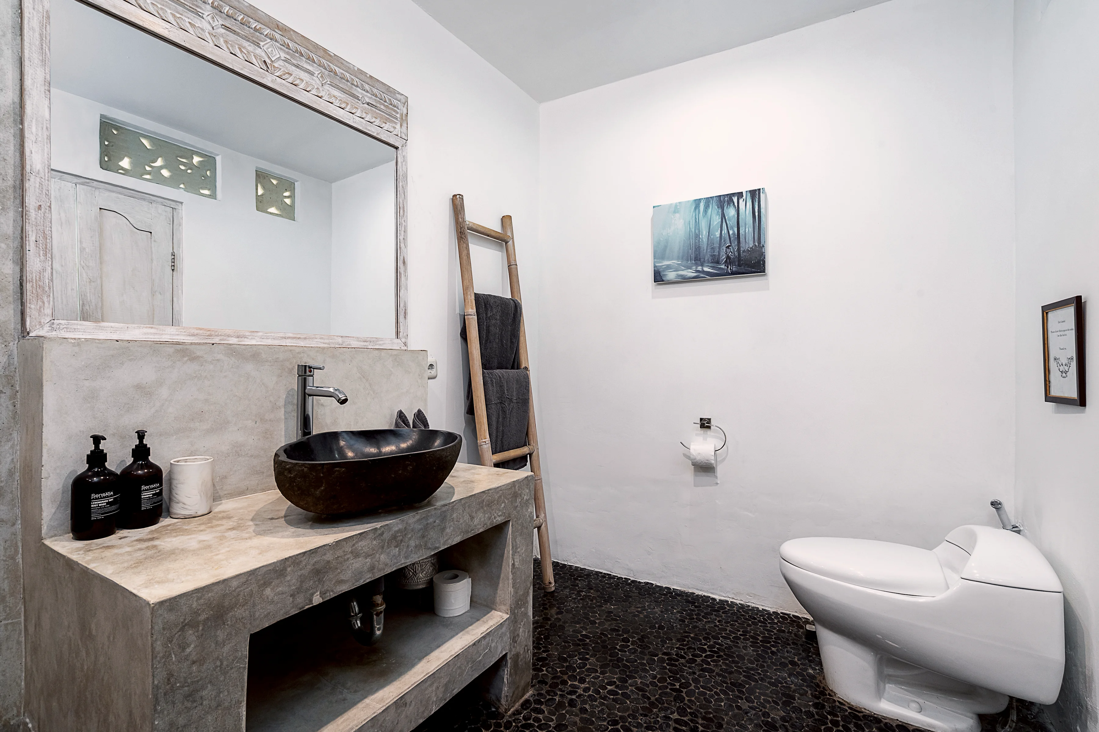 Kamar mandi dengan cermin, wastafel batu dan tangga handuk