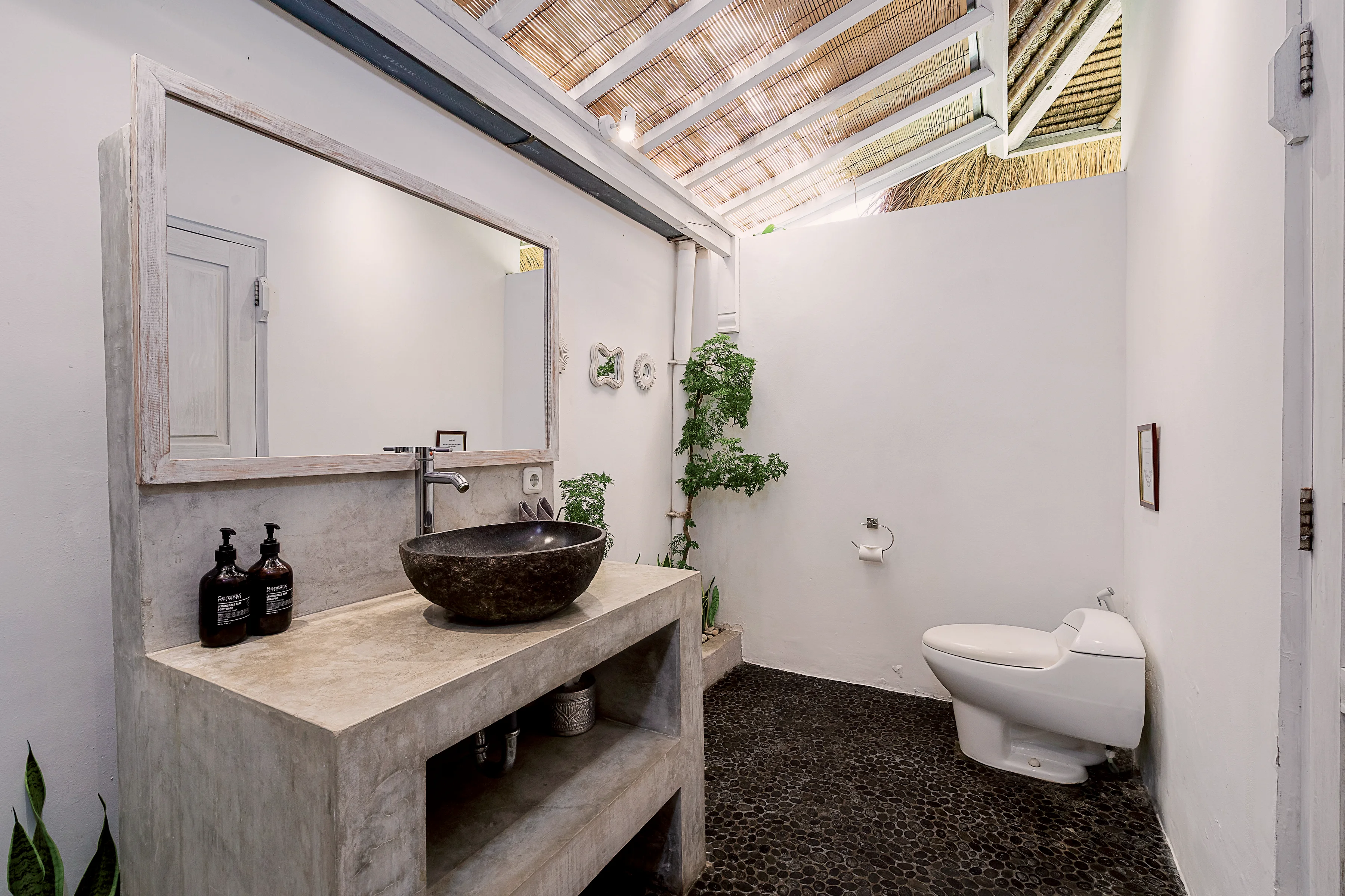 Kamar mandi utama dengan cermin, wastafel batu dan toilet