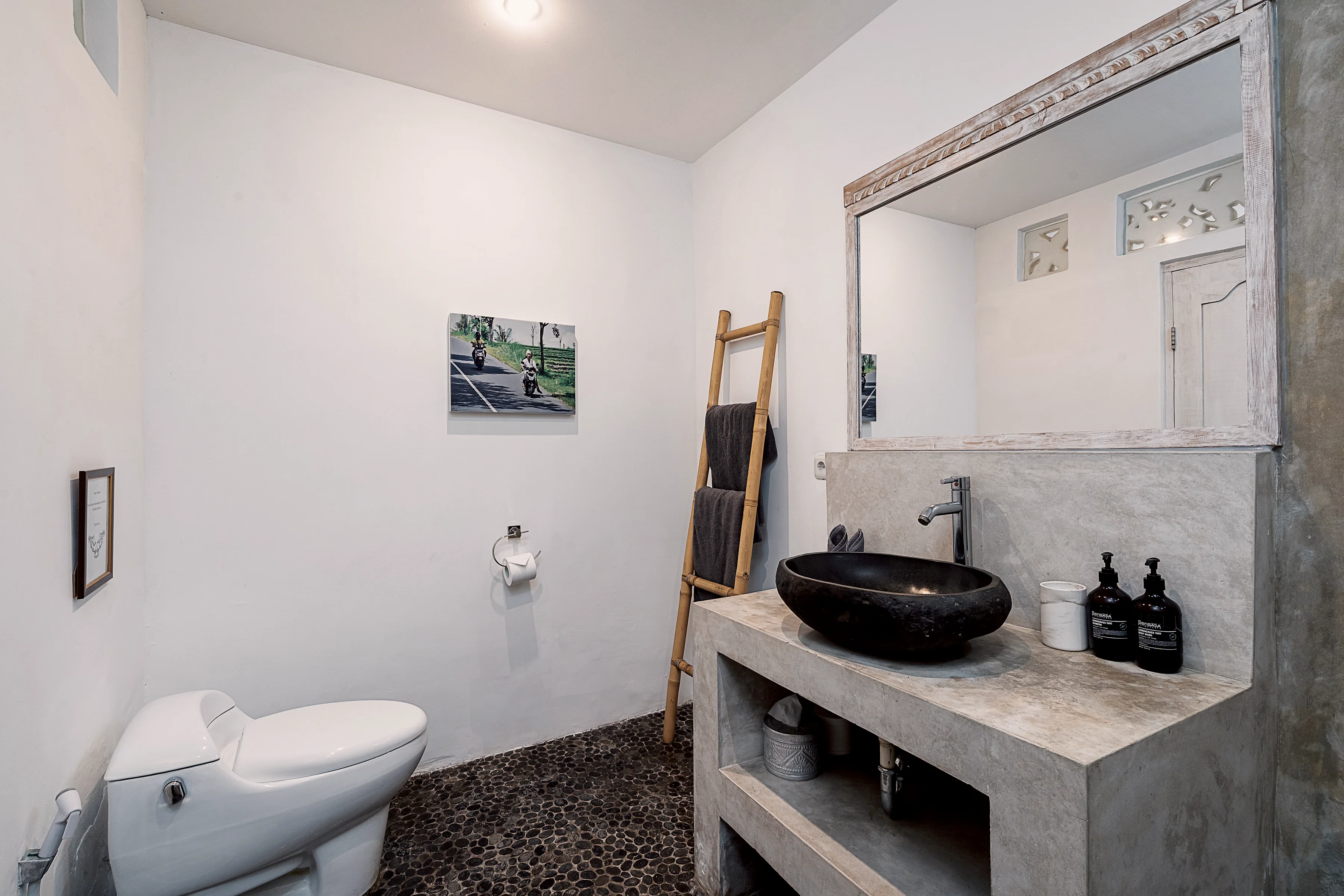 Kamar mandi dengan wastafel batu, tangga handuk dan toilet